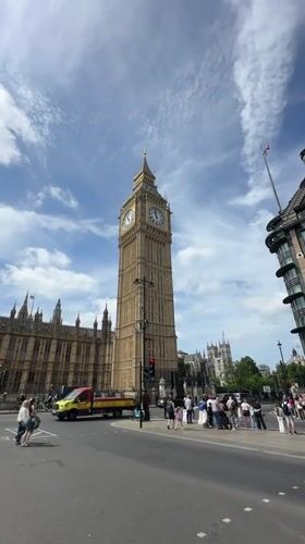 Tourists photograph Big Ben and Parliament under cloudy London skies