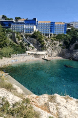 Cliffside resort, turquoise bay, and blooming coastal cactus