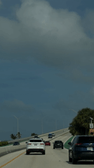 Evening traffic flows across Miami bridge under cloudy skies