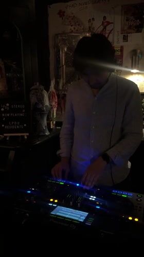 DJ working the decks at a Paris bar, Saturday night