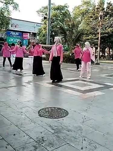 Synchronized outdoor aerobics session at a public square in Pati