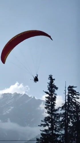 Paragliders soaring over Solang Valley on a summer afternoon