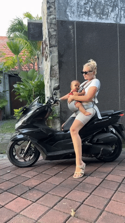 Woman, baby, dog share motorcycle ride in North Kuta