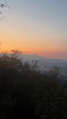 Hilltop sunset view over a valley city at dusk