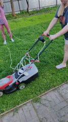 Woman mows lawn with electric mower in Заволжский, Russia
