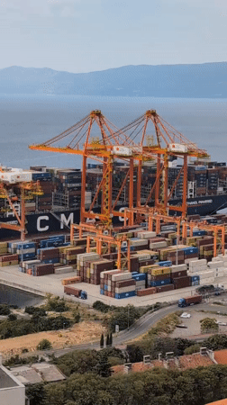 Orange cranes work a busy container ship at Rijeka port