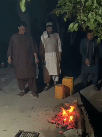 Men gather around cooking fire in Dehkheshk, Afghanistan