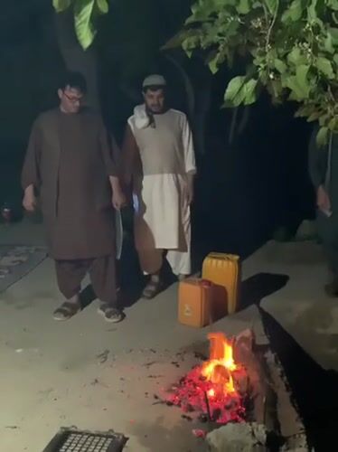 Men gather around cooking fire in Dehkheshk, Afghanistan