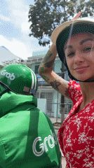 Woman in red dress rides Grab motorcycle in Vietnam