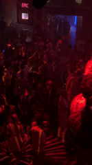 Red-lit nightclub, helium balloons, and a neon sign overhead