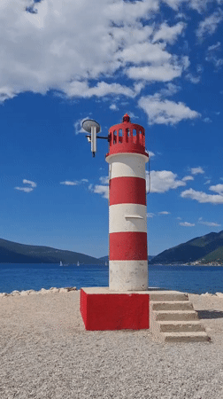 Family beach day captured near iconic lighthouse in Tivat