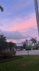 Person walks through tropical Playa del Carmen during colorful sunrise