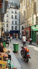 Sunny afternoon street life documented in historic Paris neighborhood
