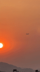 Small plane spotted flying during sunset over Pokhara, Nepal