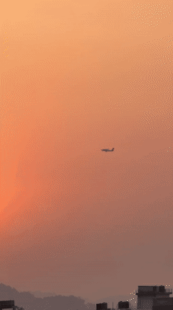Small plane spotted flying during sunset over Pokhara, Nepal