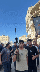 Armed crowd moves through war-damaged Gaza streets in midday procession
