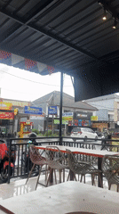 Rain shower hits outdoor cafe in Denpasar, Indonesia