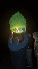 Father and child launch green sky lantern in Chaikovsky