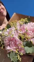 Two women pose with flower bouquet in Aprilia