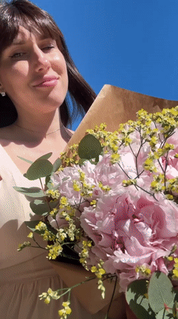 Two women pose with flower bouquet in Aprilia