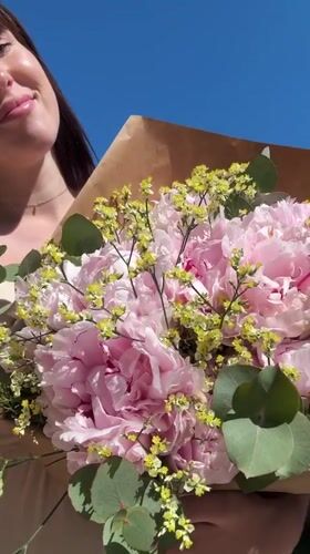 Two women pose with flower bouquet in Aprilia
