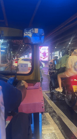 Rainy night tuk-tuk ride through Bangkok streets