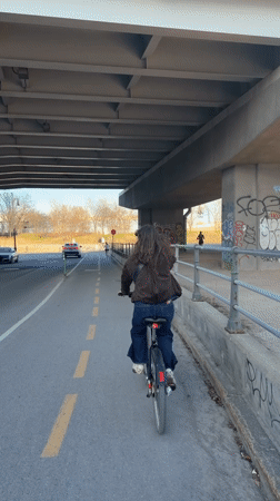 Woman cycles under Montreal overpass on Sunday evening