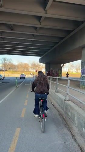 Woman cycles under Montreal overpass on Sunday evening