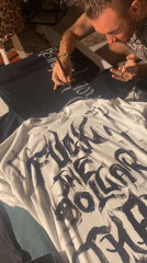 Artisans hand-paint gothic lettering on custom t-shirts in Thailand