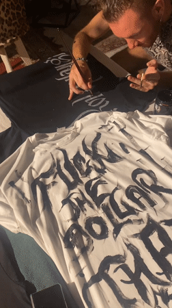 Artisans hand-paint gothic lettering on custom t-shirts in Thailand