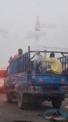 Blue cage truck moves through Lagos traffic during overcast day