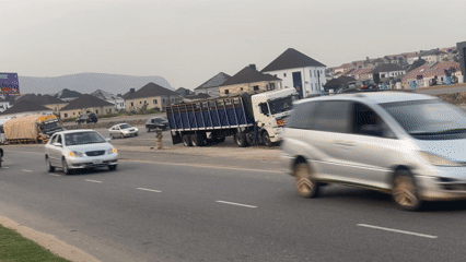 Regular traffic flows on Abuja highway under overcast skies