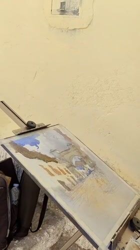 Artist paints watercolors on cobblestone street in Cuzco