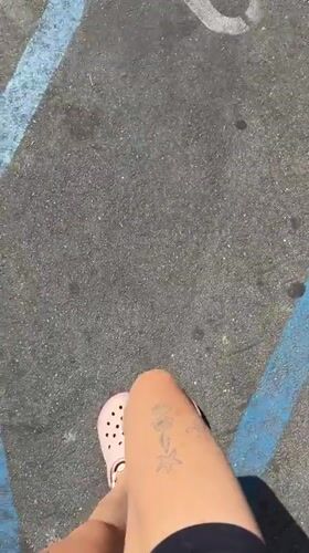 Person in pink Crocs stands on marked pavement in Malibu