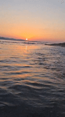 Sunset over a calm beach, silhouette on the shore