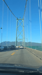 First-person drive across a suspension bridge on a clear day