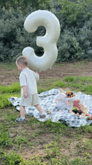 Father and child enjoy riverside outing with balloons in Chaikovsky