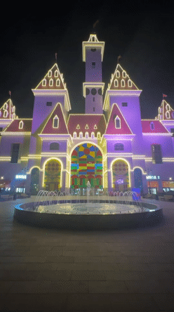 Moscow's illuminated nightscape: lit buildings, colored fountains, red sports cars