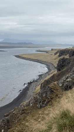 Tourist documents Hvítserkur sea stack during Iceland coastal visit