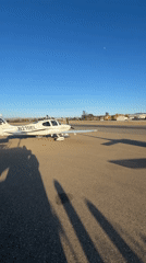 Small planes parked on a Lompoc airfield tarmac, clear skies.