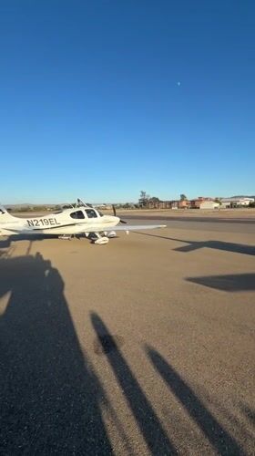 Small planes parked on a Lompoc airfield tarmac, clear skies.