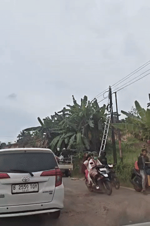 Utility workers service roadside pole in Lhokseumawe, Indonesia