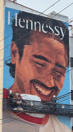 Mural in progress on a Brooklyn building facade