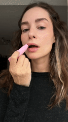 Woman applies lip balm in Kiel, Germany