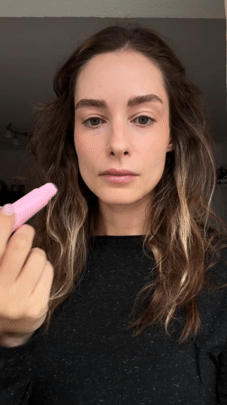 Woman applies lip balm in Kiel, Germany