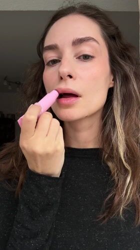 Woman applies lip balm in Kiel, Germany