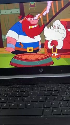 An animated cartoon featuring two characters, one resembling a pirate with a large red beard and a blue and white striped shirt, and the other resembling Santa Claus in a red suit, is displayed on an HP laptop screen. In the initial frames, the pirate is shown next to Santa Claus, who is standing on a red and green striped circular platform. The pirate then lifts Santa Claus into the air. Santa appears to have a resigned or slightly surprised expression in a close-up frame. French dialogue is visible on the screen, reading "Qu'est ce que je voulais! Alors à quoi ça sert d'écrire des lettres? Vous le..." (What did I want! So what's the point of writing letters? You...). The black keyboard of the HP laptop is visible in the foreground.