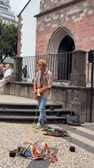 Street musician performs guitar in Funchal pedestrian square
