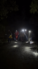 Nighttime trek through rural Indonesia, headlamps and backpacks in tow