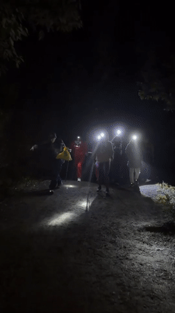 Nighttime trek through rural Indonesia, headlamps and backpacks in tow